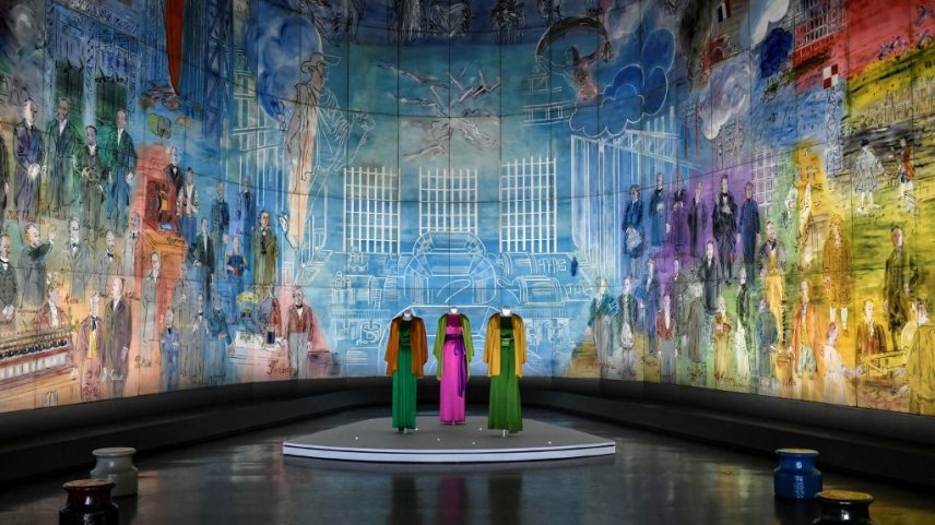 This picture shows creations of late French designer Yves Saint-Laurent surrounded by a fresco entitled 'La Fée Electricité' by artist Raoul Dufy  at Paris Modern Art Museum as part of the exhibitions "Yves Saint-Laurent at the museums" on January 24, 2022 in Paris. (Photo by STEPHANE DE SAKUTIN / AFP) / RESTRICTED TO EDITORIAL USE - MANDATORY MENTION OF THE ARTIST UPON PUBLICATION - TO ILLUSTRATE THE EVENT AS SPECIFIED IN THE CAPTION