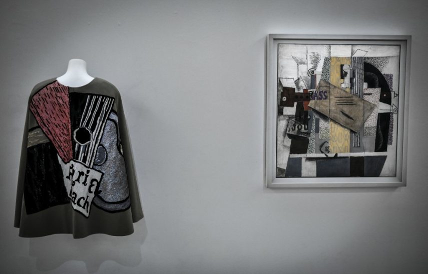 This picture shows a creation of late French designer Yves Saint-Laurent displayed next a painting entitled 'Le Violon' by Spanish artist Pablo Picasso at the Centre Pompidou (National Modern Art Museum) as part of the exhibitions "Yves Saint-Laurent at the museums" on January 25, 2022 in Paris. (Photo by STEPHANE DE SAKUTIN / AFP) / = RESTRICTED TO EDITORIAL USE - MANDATORY MENTION OF THE ARTIST UPON PUBLICATION - TO ILLUSTRATE THE EVENT AS SPECIFIED IN THE CAPTION - NO ARCHIVE - NO USE AFTER MAY 16, 2022 =