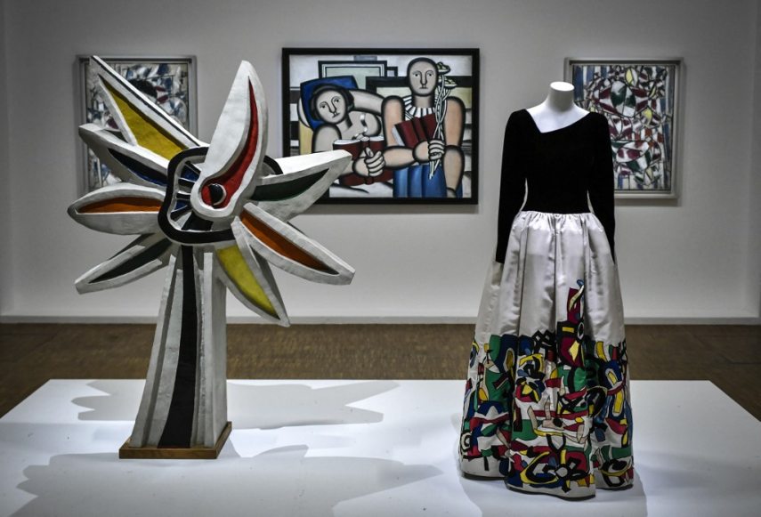 This picture shows a creation of late French designer Yves Saint-Laurent displayed next artworks by French artist Fernand Leger at the Centre Pompidou (National Modern Art Museum) as part of the exhibitions "Yves Saint-Laurent at the museums" on January 25, 2022 in Paris. (Photo by STEPHANE DE SAKUTIN / AFP) / RESTRICTED TO EDITORIAL USE - MANDATORY MENTION OF THE ARTIST UPON PUBLICATION - TO ILLUSTRATE THE EVENT AS SPECIFIED IN THE CAPTION