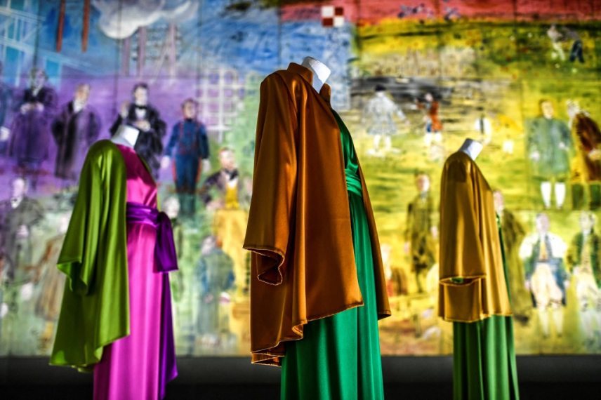 This picture shows creations of late French designer Yves Saint-Laurent surrounded by a fresco entitled 'La Fée Electricité' by Raoul Dufy  at Paris Modern Art Museum as part of the exhibitions "Yves Saint-Laurent at the museums" on January 24, 2022 in Paris. (Photo by STEPHANE DE SAKUTIN / AFP) / RESTRICTED TO EDITORIAL USE - MANDATORY MENTION OF THE ARTIST UPON PUBLICATION - TO ILLUSTRATE THE EVENT AS SPECIFIED IN THE CAPTION