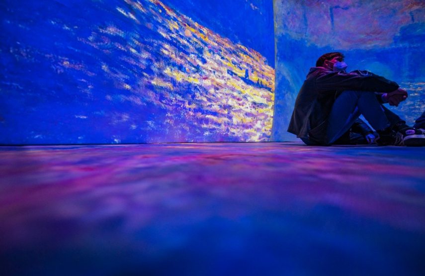 Visitors take in a 360 degree "immersive" animated projection inspired by the life and work of French painter Claude Monet (1840-1926), part of the "Monet's Garden" exhibition in Berlin on January 31, 2022. - The exhibition, which opened on January 12, 2022, mixes multimedia technology, installations and projections, combined with music, in a a bid to "bring the paintings to life in ways never before seen." (Photo by John MACDOUGALL / AFP) / RESTRICTED TO EDITORIAL USE - MANDATORY MENTION OF THE ARTIST UPON PUBLICATION - TO ILLUSTRATE THE EVENT AS SPECIFIED IN THE CAPTION