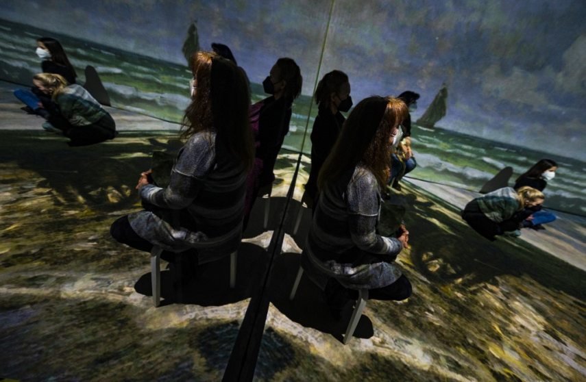 Visitors take in a 360 degree "immersive" animated projection inspired by the life and work of French painter Claude Monet (1840-1926), part of the "Monet's Garden" exhibition in Berlin on January 31, 2022. - The exhibition, which opened on January 12, 2022, mixes multimedia technology, installations and projections, combined with music, in a a bid to "bring the paintings to life in ways never before seen." (Photo by John MACDOUGALL / AFP) / RESTRICTED TO EDITORIAL USE - MANDATORY MENTION OF THE ARTIST UPON PUBLICATION - TO ILLUSTRATE THE EVENT AS SPECIFIED IN THE CAPTION