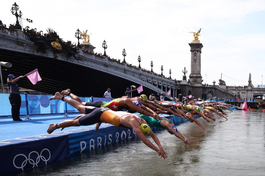 Athletes dive into the Seine river to start the swimming stage of the men's individual triathlon at the Paris 2024 Olympic Games in central Paris on July 31, 2024. (Photo by Anne-Christine POUJOULAT / AFP)