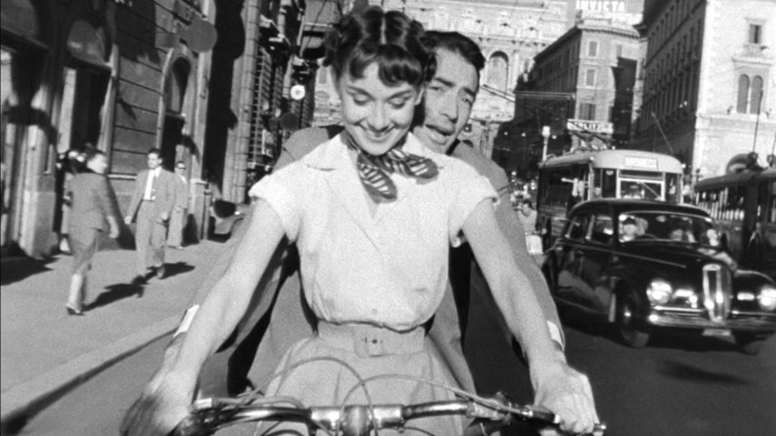 1280px-Audrey_Hepburn_and_Gregory_Peck_on_Vespa_in_Roman_Holiday_trailer.jpg