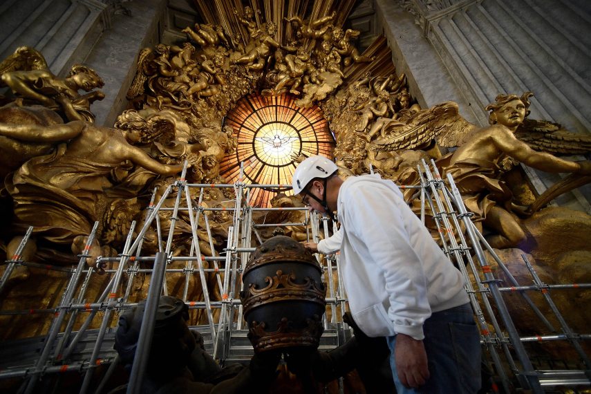 A restorer works on the Cattedra de San Pietro (The Chair of St. Peter ) during its restoration, in the Vatican, on October 8, 2024. The gold glows against the dark bronze and the carved bees have emerged once again on the baldachin in Saint Peter's Basilica, thanks to its first restoration in 250 years. Gian Lorenzo Bernini's Baroque masterpiece, a towering canopy over the high altar, has been given a facelift in honour of next year's Catholic Jubilee. The 29-metre-high structure (95 feet) -- the size of a ten-storey building, comprising four bronze columns and a canopy bearing four 2.5-tonne (5,600 pounds) angels -- has been shrouded in scaffolding since work started in February (Photo by Filippo MONTEFORTE / AFP)