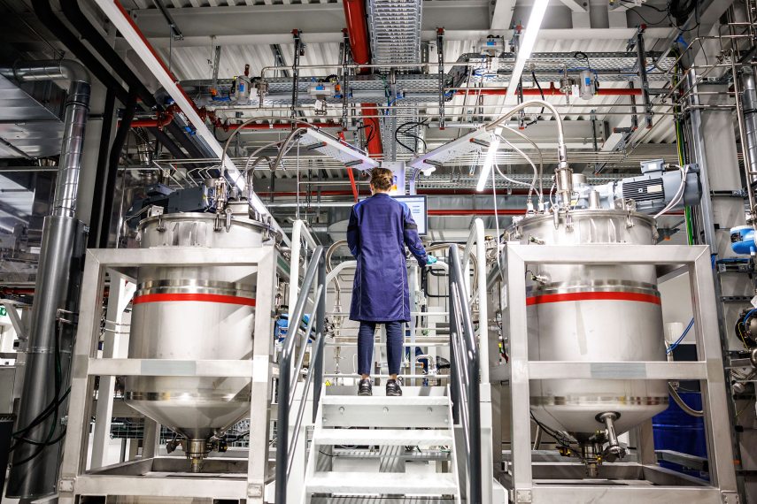 26 October 2023, Bavaria, Vaterstetten: Desiree Grießl, responsible for electrode technology development at BMW, stands between two mixing containers in which the battery paste ("slurry") is mixed during a press tour of the BMW Cell Manufacturing Competence Centre (CMCC) in a factory hall in the "metering and mixing" area. Photo: Matthias Balk/dpa (Photo by MATTHIAS BALK / DPA / dpa Picture-Alliance via AFP)