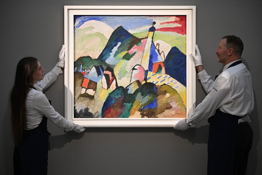 Employees poses with an artwork entitled 'Murnau mi Kirche II' (Murnau with Church II) by Wassily Kandinsky, during a photocall at Sotheby's auction house in central London on February 22, 2023. The painting is expected to realise in the region of USD 45 million dollars (EUR 42 million euros , GBP 37 million pounds at auction in March. (Photo by JUSTIN TALLIS / AFP) / RESTRICTED TO EDITORIAL USE - MANDATORY MENTION OF THE ARTIST UPON PUBLICATION - TO ILLUSTRATE THE EVENT AS SPECIFIED IN THE CAPTION