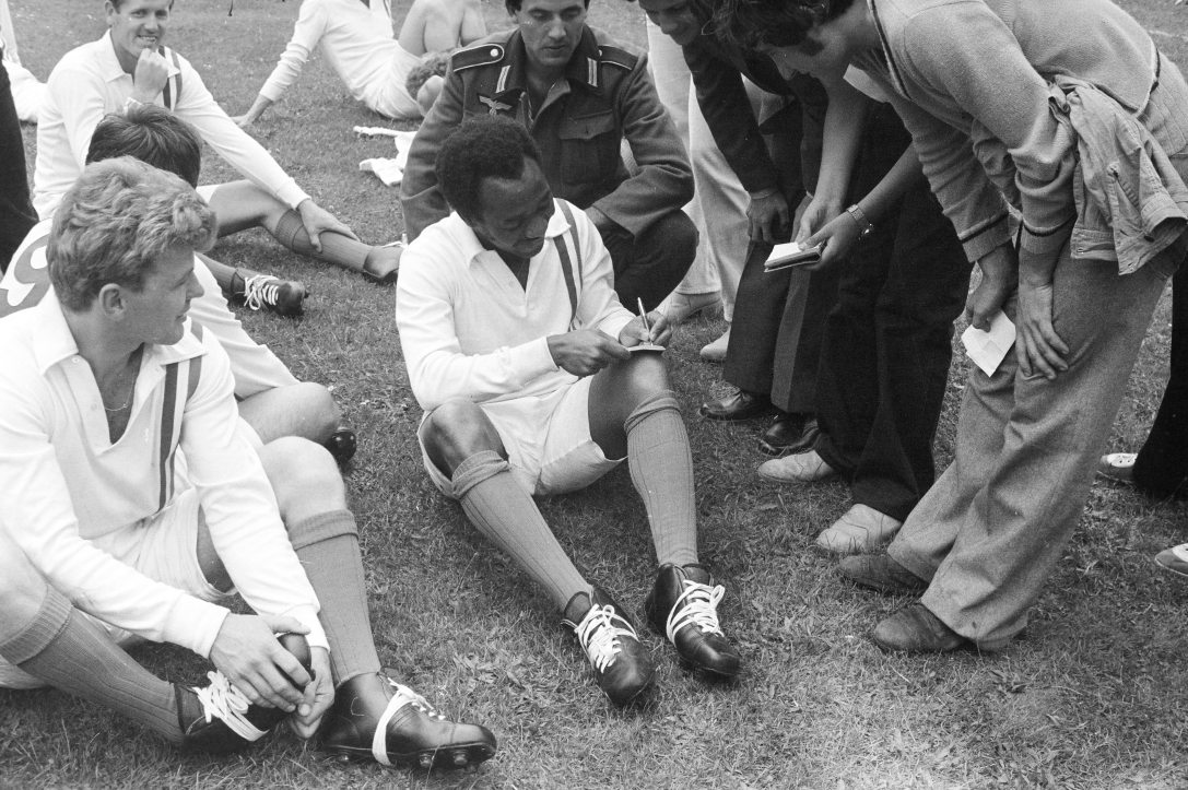 Pelé, háromszoros világbajnok brazil labdarúgó autogramot ad a „Menekülés a győzelembe” című film forgatási szünetében az MTK pályán 1980-ban. Fotó: Fortepan / Tóth Katalin