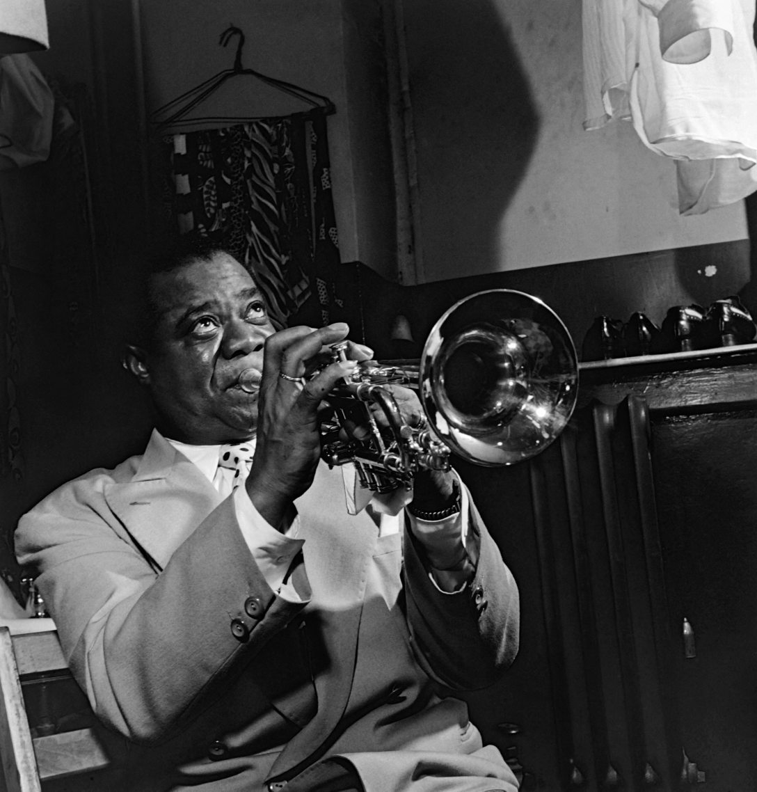 Louis Armstrong amerikai trombitás és jazzmuzsikus az öltözőjében próbál, mielőtt fellépne egy New York-i jazzkabaréban, 1947-ben. Fotó: Eric Shcwab / AFP