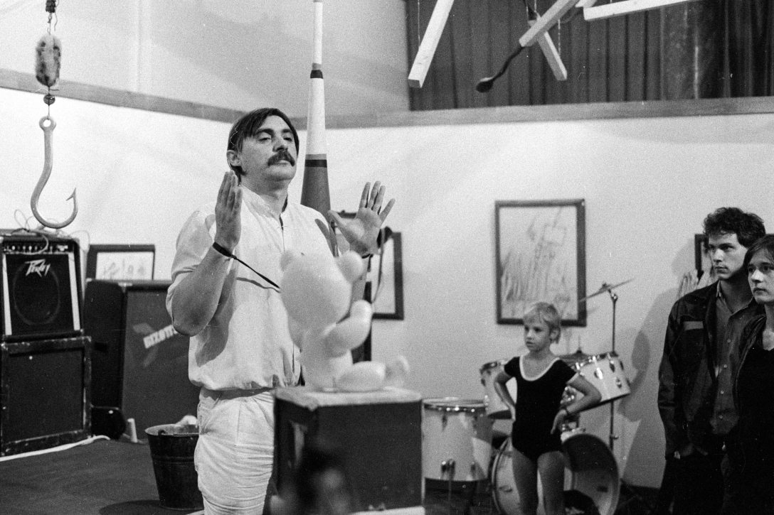 feLugossy László festőművész, performer, a kép jobb szélén Fákó Árpád képzőművész, zenész és Szilágyi Lenke fotóművész ef Zámbó István kiállításmegnyitóján 1983-ban. Fotó: Várkonyi Péter / Fortepan