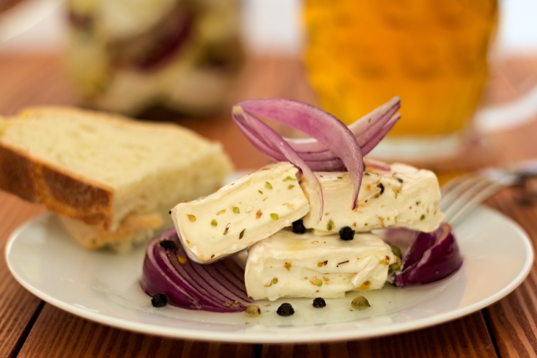 Olajban pácolt camembert lila hagymával, fűszerekkel és gyógynövényekkel. A kép illusztráció. Fotó: Shutterstock