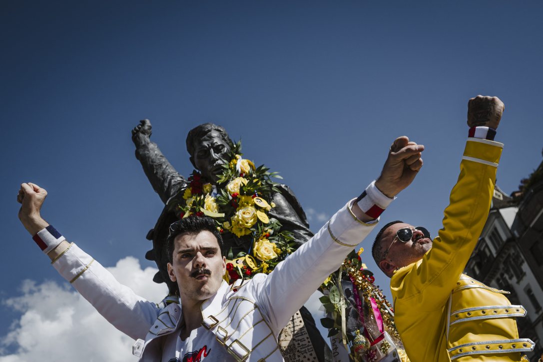 Rajongók pózolnak Freddie Mercury szobránál a svájci Montreux-ben. Fotó: GABRIEL MONNET / AFP