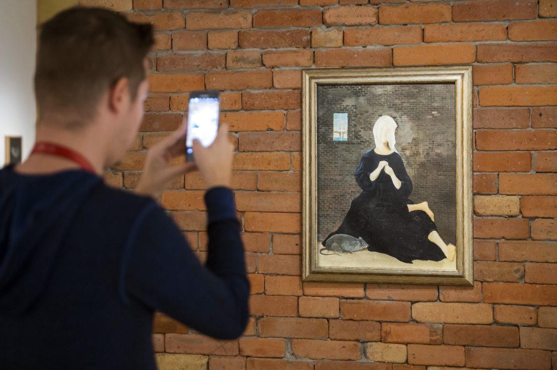Érdeklődő az egyetlen magyar klasszikus szürrealista festőként számon tartott, 90 éve született Ország Lili munkásságát bemutató Árny a kövön című kiállítás megnyitóján. Fotó: Mohai Balázs / MTI