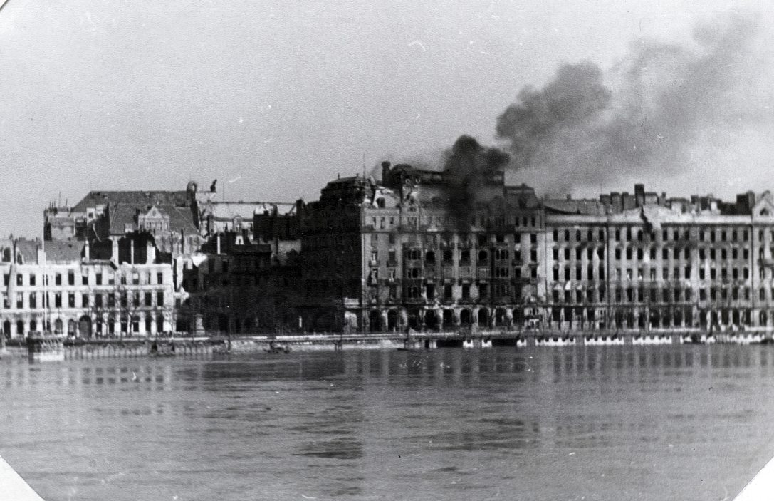 Az Eötvös téri Ritz szálló / Dunapalota 1945. január 15-én bombatalálattól lángra kapott és több napon át lobogva, teljesen kiégett. Mögötte az Apáczai Csere János (Mária Valéria) utca házai, jobbra a Dunakorzó. Fotó: Fortepan / Vörös Hadsereg