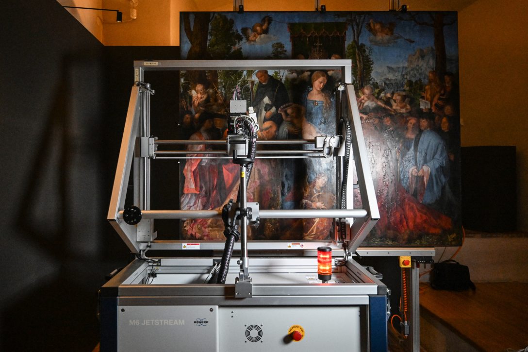 Albrecht Dürer Rózsafüzér-ünnep című reneszánsz mesterműve a prágai Nemzeti Galériában 2026. szeptember 14-én, miközben egy szkenner nagy felbontású adatokat rögzít a festmény felületéről. Fotó: Michal CIZEK / AFP