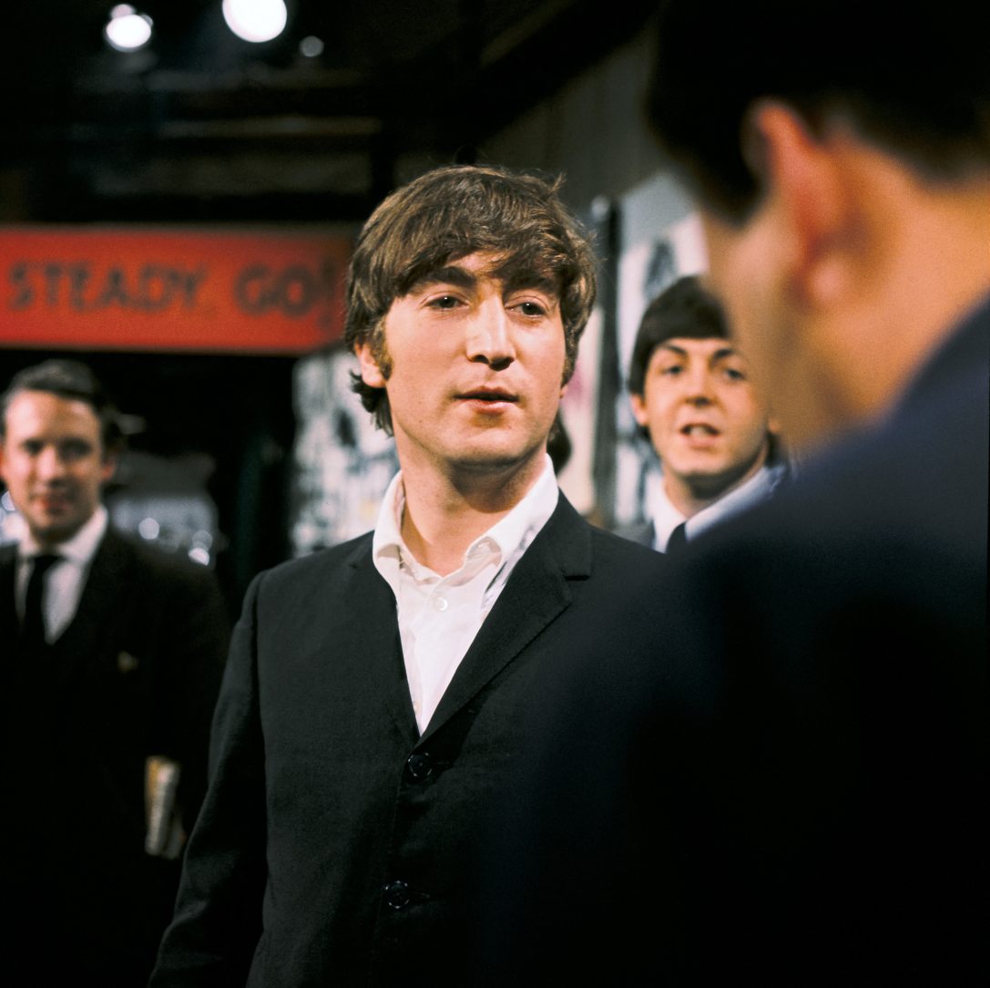 John Lennon és a háttérben Paul McCartney a The Beatles fellépésén a Ready Steady Go! című könnyűzenei műsor londoni stúdiófelvételén 1964. január 1-jén. Fotó:  KIPPA / ANP / ANP via AFP