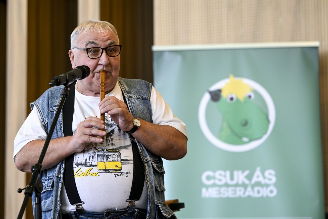 Mikó István, a Mesepostás István bácsi furulyázik a Csukás Meserádió, a közmédia gyerekcsatornájának egyéves születésnapi ünnepségén a MÜPA Üvegtermében 2025. augusztus 30-án. Fotó: MTI/Purger Tamás